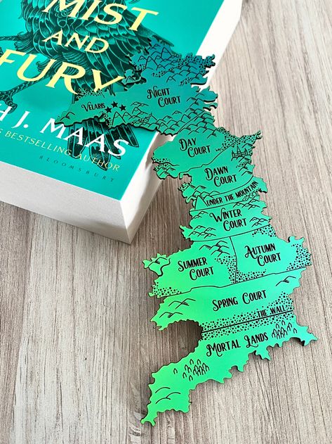 Explore the magical world of Prythian with this officially licensed ACOTAR bookmark. The iridescent map showcases the seven courts, mortal lands, and under the mountain, providing a visual guide for all your reading adventures. (No need for a magic portal, just flip a page!) From A Court of Thorns and Roses, by Sarah J. Maas, c 2015. Artwork by Amy Olszak of zoo&roo. Created with permission of Writers House LLC acting as agent for the author. Sjm Bookmarks, A Court Of Thorns And Roses Bookmark, Acotar Crafts, Acotar Map, Prythian Map, Acotar Bookmarks, Bookish Crafts, Book Rebinding, Under The Mountain