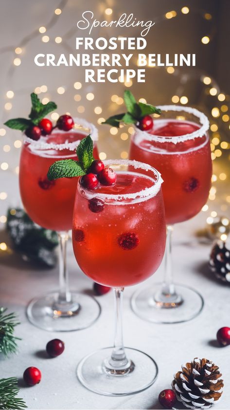 Three glasses of frosted cranberry bellini garnished with mint and cranberries, surrounded by festive decorations. Holiday Bellini Recipe, Limoncello Cranberry Cocktail, Sparkling Cranberry Cocktail, Christmas Bellini, Cranberry Cocktail Punch, Cranberry Bellini Recipe, Cranberry Bellini, Fruity Vodka Drinks, Bellini Cocktail Recipes