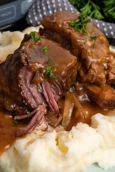 Two short ribs over mashed potatoes and covered in gravy. Beef Short Ribs Crock Pot, Crockpot Short Ribs, Short Ribs Crock Pot, Ribs Crock Pot, Slow Cooker Apple Cobbler, Slow Cooker Short Ribs, Salisbury Steak Crockpot, Christmas Party Centerpieces, Slow Cooker Bbq Beef