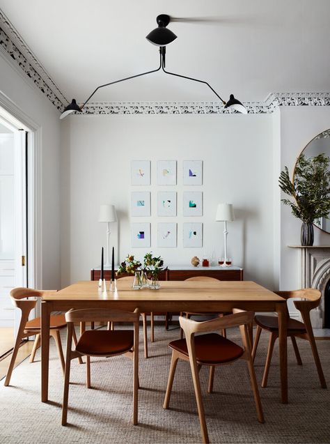 Dining room with white oak table, leather-seat chairs, and walnut console on a houndstooth rug, featuring original trim and mid-century lighting. Houndstooth Rug, Plaster Lamps, Original Fireplace, Mid Century Light Fixture, Light Oak Dining Table, White Oak Furniture, Cleaning White Walls, White Oak Table, Walnut Console