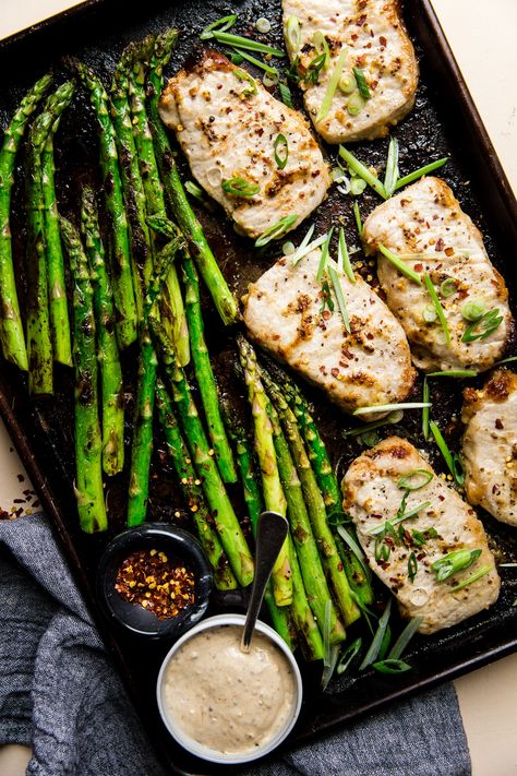 Baked Boneless Pork Chop and Asparagus Sheet Pan Dinner  by The Modern Proper. One pan. 30 minutes. Irresistibly delicious and healthy, this tender baked pork chop and asparagus sheet pan dinner gets a major flavor boost from a simple, genius garlicky mayo-mustard sauce. Modern Proper Sheet Pan, Pork Asparagus Recipes, Sheet Pan Pork Chops And Asparagus, Pork Chop Asparagus Recipes, Pork Chops With Asparagus, Pork Chops And Asparagus In Oven, Pork Chop And Asparagus Recipes, Pork And Asparagus Recipes, Pork Chops And Asparagus