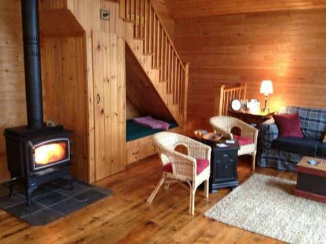 What a cute place to curl up and read a book at Christmas time, with a fire in the woodstove! I love the cupboard under the stairs (like Harry Potter!) and the wood walls - it looks like a cozy log cabin :) Cupboard Under The Stairs, Camp House, Cozy Log Cabin, Metal Building Home, Under Stairs Cupboard, Under The Stairs, Lakeside Cottage, Cozy Seats, Cottage Rental