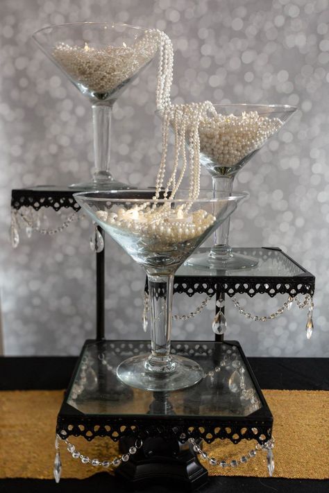 These DIY Gatsby party centerpieces are awesome! I love the ones made with ostrich feathers and the champagne glass tower. A perfect addition to my roaring 20s party decor. #entertainingdiva #roaring20s #gatsbywedding #centerpieces #partydecor #diypartydecor Champagne Glass Tower Gatsby Party, Gatsby Party Ideas 1920s, The Great Gatsby Centerpieces, 1920s Party Centerpieces, 20s Decorations 1920s Party, 1920s Centerpieces Roaring 20s, End Of My Roaring 20s Party, The Great Gatsby Decorations, 20s Party Centerpieces