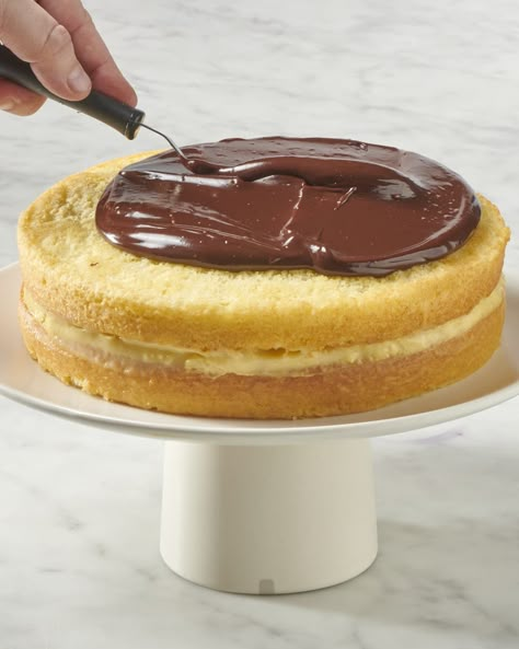 a whole boston cream pie on a cake stand being topped with chocolate ganache Vegan Holiday Appetizers, Boston Cream Pie Recipe, Fluffy Sponge Cake, Boston Cream Cake, Pie Designs, Pastry Cream Filling, Choctaw Nation, Traditional Desserts, Waffle Cookies