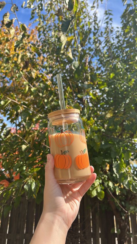 Glass Beer Can decorated with Orange Pumpkin Vinyl Designs. The cup consists of outlined pumpkins and filled in pumpkin designs. The product can be bought with a bamboo lid and a glass straw! Fall Glass Cups, Coffee Glass Aesthetic, Beer Glass Cups, Glass Aesthetic, Pumpkin Cups, Pumpkin Beer, Coffee Jars, Beer Cup, Painted Cups