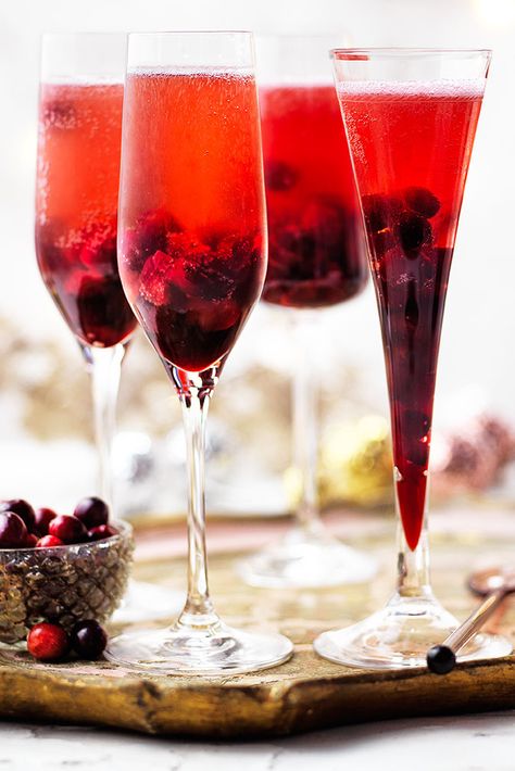 Festive fruit gives this Kir Royale an extra special twist. With a syrup made from cranberries, Crème de Cassis and sugar this Champagne cocktail is the perfect Christmas party idea. | Tesco Cranberry Bellini Recipe, Cocktail Recipes Christmas, Healthy Cocktail Recipes, Cranberry Drinks, New Years Cocktails, Bellini Recipe, Christmas In England, Kir Royale, Dinner Party Desserts