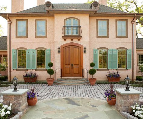 Peach terra-cotta and muted green make a unique color scheme on this symmetrical home. See more home exteriors: http://www.bhg.com/home-improvement/exteriors/?socsrc=bhgpin092212peachterracotta Exterior Color Combinations, Stucco Colors, Green Shutters, Best Exterior Paint, House Paint Color Combination, European Doors, Door Exterior, Stucco Homes, French Style Homes