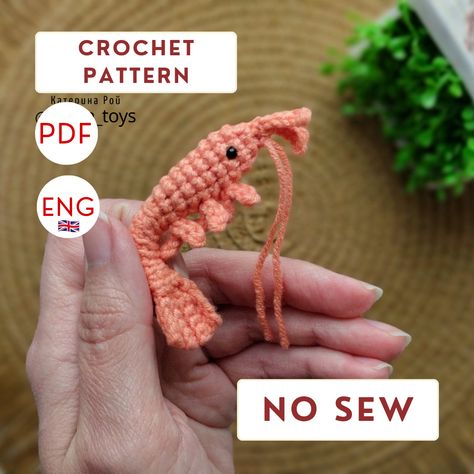 Make your space even more enchanting with this incredibly adorable 2-inch crocheted mini shrimp! Adding a hint of effortless romance and charming allure to your home, this delightful accessory is sure to captivate. Crafted with meticulous attention to detail, this shrimp shines with unmatched craftsmanship and care. Whether you're adding it to your own collection or gifting it to a loved one, it's a perfect way to showcase its delightful character! Emotional Support Shrimp Crochet, Crochet Shrimp Free Pattern, Shrimp Crochet Pattern, Crochet Shrimp, Plushie Ideas, 2024 Crochet, Crocheted Ideas, Crochet Market, Easy Crochet Animals