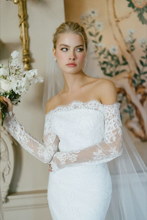 Strapless trumpet gown of corded lace featuring a classic scalloped hem, highlighted by Chantilly lace underlay and buttons to the godet. Pairs with the Collier Toppers an off the shoulder long sleeve top of corded lace, featuring scalloping along the neckline with button & loop closure at back and the Collier Veil a cathedral length veil with classic scalloped edge at back, fading to smaller appliques nearer the comb. Wedding Dress Topper, Illusion Neckline Wedding Dress, Dress Topper, Bridal Trends, Cathedral Length Veil, Anne Barge, Short Veil, Long Sleeve Wedding Dress Lace, Trumpet Gown