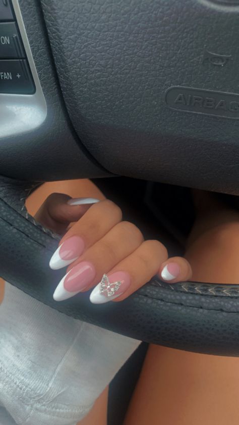 Oval Nails Designs Butterfly, Nails Almond With Diamond, Almond Nails With Butterfly Charm, French Tip Nails With Butterfly Charm, White Butterfly Nails Almond, Almond French Tip Nails With Charms, French Tip With Butterfly Charm, Butterfly Diamond Nails, Almond French With Gems