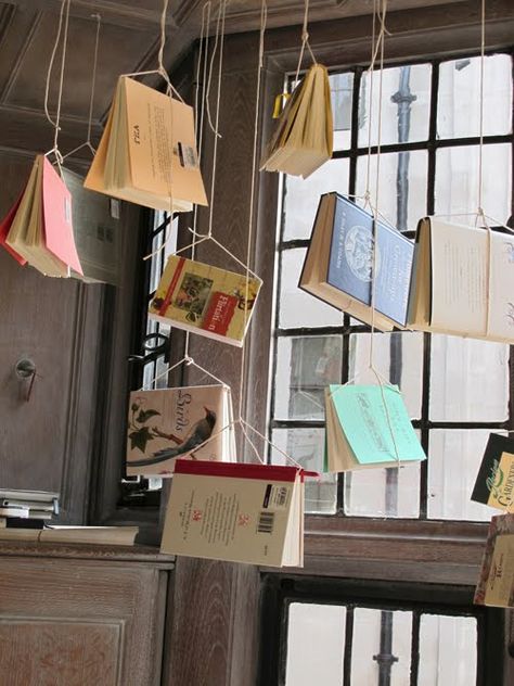 hanging books. Book Store Shelves Design, Shop Hanging Display, Library Exhibition Ideas, Hanging Photo Backdrop, Hanging Window Display, Hanging Book Pages, Bookstore Window Display Ideas, Back To School Retail Display, Book Shop Window Display