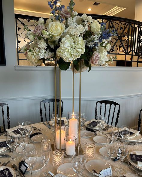 An elevated blush and white wedding centerpiece combines elegance and romance, creating a sophisticated focal point for your guest tables. Here we chose our gold Harlow stand with pillar candles in varying heights and gold rimmed votive candles for additional shimmer on the the tables. @tarrytownhouse Tall Flower Centerpieces With Candles, Tall Flower Centerpieces, Votive Candles Wedding, Blush And White Wedding, Wedding Votives, White Wedding Centerpieces, Tall Flowers, Flower Centerpieces Wedding, Black Candles