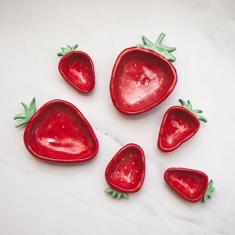 These hand painted ceramic strawberry ring dishes are similar sizes as actual strawberries! No two pieces are exactly alike, ensuring that you have a unique item every time. Enjoy a one-of-a-kind jewelry dish that adds a special touch to your home while offering an elegant solution for organizing your favorite jewelry pieces. Ceramic Strawberry, Strawberry Dishes, Strawberry Ring, Air Dry Clay Projects, Ring Dishes, Pottery Painting Designs, Clay Diy Projects, Clay Crafts Air Dry, Pottery Crafts