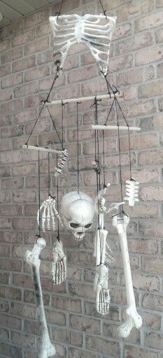 DIY Spooky halloween wind chimes.  A bag of bones, twine, wooden dowels. Skull Wind Chimes, Halloween Wind Chimes, Halloween Wind Chimes Diy, Blair Witch Decorations, Swamp Witch Halloween Decor, Blair Witch Halloween Decorations, Diy Bones Halloween, Bag Of Bones Halloween Ideas, Voodoo Decor