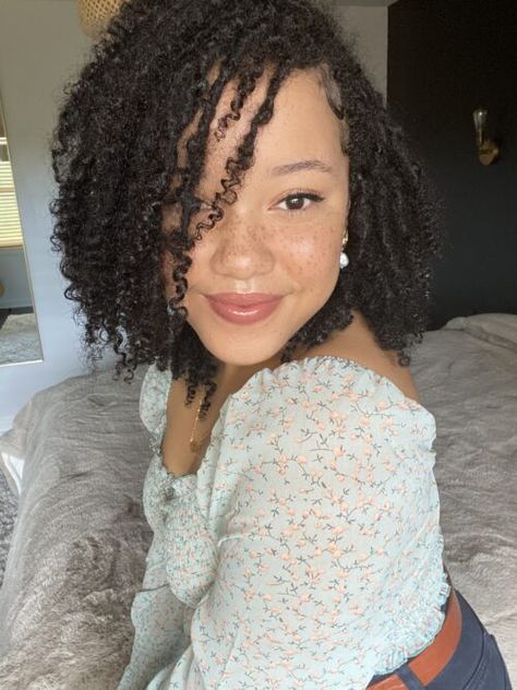 woman with locs sitting on bed smiling at camera. She has freckles and is wearing a light blue shirt with flowers on it. She has a leather brown belt on as well. Natural Curl Locs, Locs On Biracial Hair, Locs Mixed Hair, Locs For Curly Hair, Locs On Type 3 Hair, Real Locs With Curly Ends, Natural Locs With Curly Ends Black Women, Mixed Hair Locs, Curly End Locs Natural