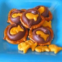 Chocolate, gold fish, and pretzels for a sweet ocean snack.  (I would probably use white chocolate with blue food coloring.) Beach Birthday Party Food Ideas, Gone Fishing Birthday Party Food, Fish Snacks For Kids, Ocean Themed Party Food, Ocean Snacks, Vbs Snacks, Goldfish Snack, Hersey Kisses, Ocean Ideas