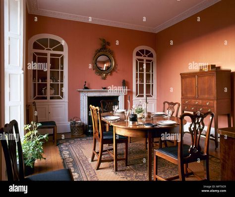 Download this stock image: Traditional dining room with terracotta colour walls, wood side cabinet, oval dining table and chairs, and arched, built-in china cabinets flanking a - MFT6CR from Alamy's library of millions of high resolution stock photos, illustrations and vectors. Terracotta Dining Room, Modern Crockery, Crockery Cabinet Design, Dining Room Colour Schemes, Built In China Cabinet, Crockery Cabinet, Dining Room Paint Colors, Cabinet Designs, English Interior