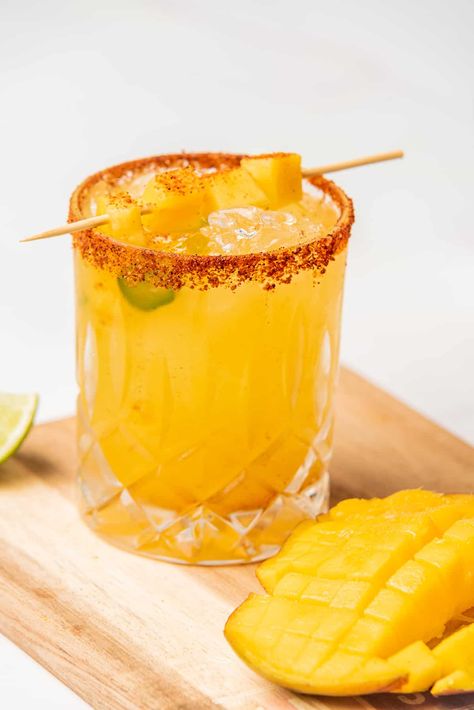 This Spicy Mango Margarita is a lively blend of sweet and spicy. Just one sip of this cocktail, and you'll feel like you feel like you're on a sunny beach vacation in Mexico. Spicy Mango Margarita, Mango Margarita Recipe, Spicy Margarita Recipe, Mango Cocktail, Classic Margarita Recipe, Spicy Drinks, Spicy Cocktail, Mango Margarita, Spicy Margarita