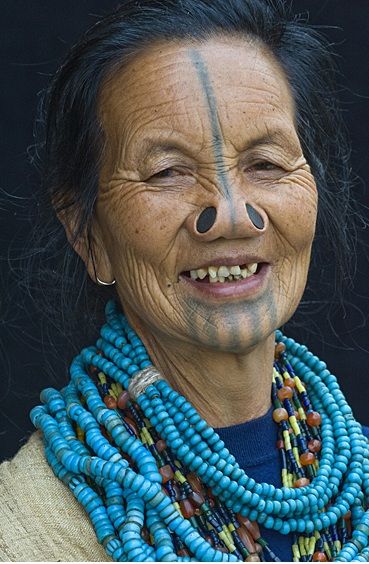 *Apatani woman, India. Their villages were constantly raided by neighboring tribes, and the women kidnapped. To make themselves unattractive to the other tribes, Apatani women began wearing these hideous nose plugs and tattooing their faces with a horizontal line from the forehead to the tip of the nose, and 5 lines on their chins. Let’s face it, that turns off any raider in search of beautiful women to have his way with. Ziro Valley, Huge Blackheads, Apatani Tribe, Arunachal Pradesh, Wooden Plugs, Old Faces, Old Woman, Traditional Tattoos, About People