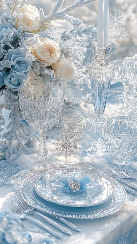 Elegant winter table setting with icy blue and silver accents, including snowflake glasses, crystal cutlery, and frozen roses. Winter Wonderland Flower Centerpieces, Winter Wonderland Tablescape Ideas, White Table Setting Christmas, Winter Wonderland Dinner Party, Winter Blues Party, Baby Blue Christmas Decor, Winter Wonderland Table Setting, Blue Christmas Aesthetic, Winter Wonderland Aesthetic