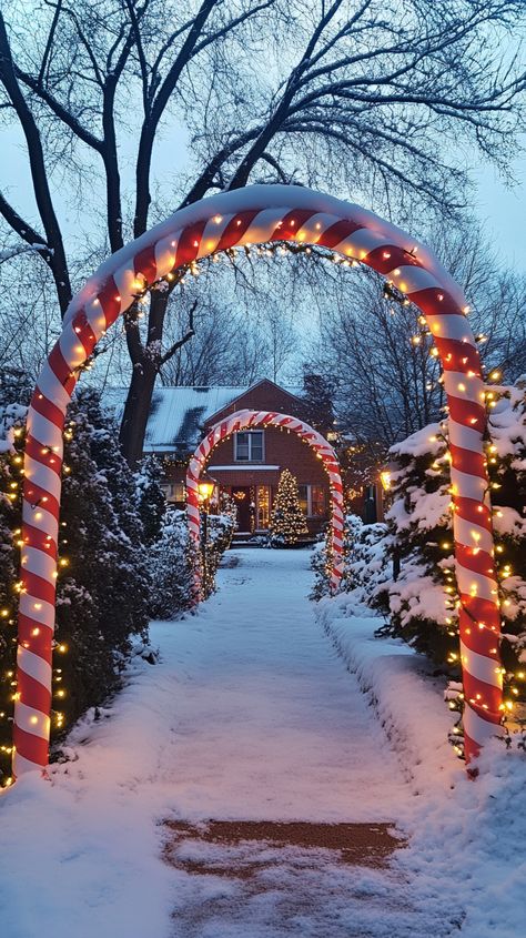 A festive candy cane archway with lights welcomes visitors to a snow-covered garden, surrounded by illuminated trees. Christmas Street Decor Ideas, Christmas Lighting Ideas, Twinkling String Lights, Canes Decor, Reindeer Lights, Xmas Dress, Covered Walkway, Christmas Planters, Star Lanterns