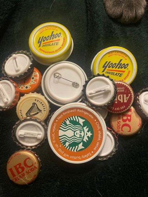 It is a bunch of different bottle caps such as yoohoo, Starbucks, IBC, Abita, and a few others with pin backs on the back of them to make them into pins :3 Bottlecap Pin, Can Tabs, Warm Colour Palette, Cream Soda, Bottle Caps, Diy Accessories, Bottle Cap, Paper Clip, Pins