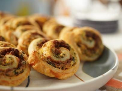 Spinach, Artichoke and Sausage Pinwheels Recipe | Jeff Mauro | Food Network Apple Walnut Stuffing, Spinach Artichoke Pinwheels, Artichoke Pinwheels, Walnut Stuffing, Sausage Pinwheels, Thanksgiving Classics, Katie Lee Biegel, Puff Pastry Pinwheels, Pinwheels Recipe