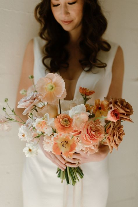 A breathtaking bridal bouquet in sophisticated color palette of taupes, blushes, and oranges. We used all the best spring flowers to bring some unexpected color into this black-tie wedding. We loved bringing our florals into Block 41, because it is the perfect backdrop for a dreamy wedding ceremony. See more from this stunning wedding editorial over on our blog. Photo by Jessica Woods Jessica Woods, Taupe Wedding Colors, Flowers Installation, Apricot Wedding, Bohemian Wedding Bouquet, Wedding Pastel, Taupe Wedding, Elegant Wedding Bouquets, Peach Bouquet