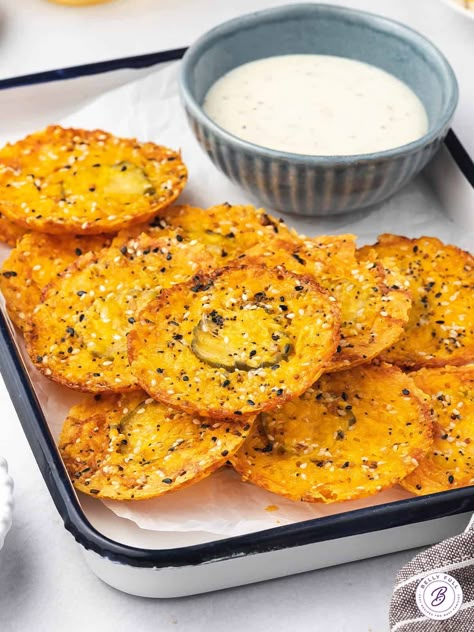 Made with just 3 ingredients, these Dill Pickle Cheddar Cheese Chips are an easy, low carb snack idea. They're a nice alternative to potato chips when that salty craving hits - ready in 15 minutes. Pickle In Cheese, Oven Baked Pickles With Cheese, Dehydrated Pickle Chips, Fried Cheese And Pickles, Keto Cheese Pickle Chips, Cheese Pickles Oven, Dill Pickle Snack Ideas, Baked Pickles And Cheese, Pickle Cheese Chips