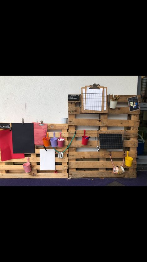 Pallets In Classroom, Mark Making Early Years Outdoors, Outdoor Literacy Area, Eyfs Outdoor Art Area, Outdoor Mark Making Area Eyfs, Mark Making Outdoors Eyfs, Painting Area Eyfs, Outdoor Writing Area Eyfs, Eyfs Outdoor Area On A Budget