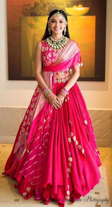 A bride in a unique drape blouse for her mehndi Sagai Outfit Indian Weddings, Leghana Design, Lehriya Lehenga, Designer Traditional Dresses, Lehenga Designs Party Wear, Bandhani Dress Party Wear, Unique Lehenga Designs Party Wear, Unique Lehenga Designs, Unique Lehenga