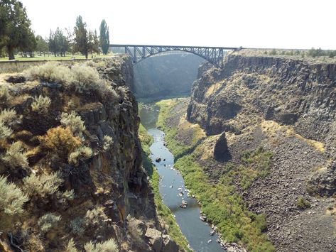 Just off Hwy 97 in Oregon, is a steep blast gorge carved thousands of years ago in the high desert plains of Central Oregon.  The Crooked River Gorge is best seen at the Peter Ogden State Park - a wayside just off the highway.  The stunning gorge is quite a site! Oregon has a wide variety of landscapes and geological wonders.  Just on the east side of the Cascade Mountains, the High Desert is a world away from the valleys west of the Cascades. High Desert Oregon, Dnd Setting, Desert Plains, Gorge Oregon, Beautiful Bridges, Smith Rock State Park, Visit Oregon, Pacific Northwest Travel, Multnomah Falls