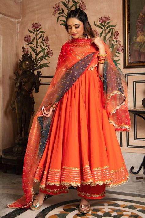 Orange angrakha style anarkali with gota patti trims. Comes with straight pants and bandhej dupatta. Component: 3 Pattern: Print Type Of Work: Bandhej Print Neckline: V neck Sleeve Type: Half Fabric: Cotton and Organza Color: Orange Other Details:  Anarkali Length: 48 inches Pant Length: 38 inches Sheer dupatta with gota patti scalloped border Tie up on the side Occasion: Puja - Aza Fashions Jaipur Anarkali, Orange Angrakha, अनारकली सूट, Angrakha Style Anarkali, V Neck Anarkali, Cotton Anarkali Suits, Bandhej Dupatta, Bandhej Print, Anarkali Designs