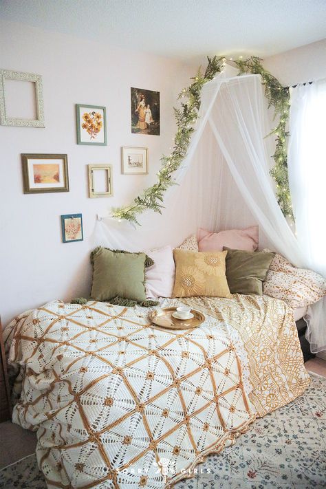 For this year's dorm room makeover series, we took on a boho cottagecore style for a first year student. With dorm-friendly dorm-safe hacks, we transformed her study-from-home space into a whimsical floral vintage dream. We installed a bed canopy, thrifted finds, and a tool-free thrifted gallery wall to make her space look like grandma's bedroom - but elevated. Click to find out how to makeover your bedroom with the cottagecore aesthetic. Floral Bedroom Ideas Vintage, Floral Bed Canopy, Canopy Room Aesthetic, Bedroom Ideas Whimsical, Floral Aesthetic Room Decor, Canopy Dorm Room, Cottagecore Bed Canopy, Vintage Looking Bedroom, Bed Canopy Dorm