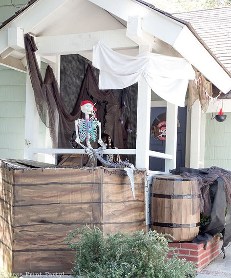 DIY Halloween front porch decorations Ideas. Transform your front porch into a haunted pirate ship this Halloween, complete w spooky skeleton mermaid and pirate, lights and cheap cardboard pirate ship. The skeleton mermaid got a makeover and the pirate skeleton a dashing hat with braids. A chalkboard pumpkin and a pirate wreath round up the look. Great ideas for a pirate party also. #halloween #pirateship #skeleton #spooky by Press Print Party! Pirate Ship Halloween, Diy Pirate Ship, Cardboard Pirate Ship, Pirate Halloween Decorations, Homemade Pirate Costumes, Flamingo Party Supplies, Pirate Halloween Party, Diy Pirate, Pirate Party Decorations