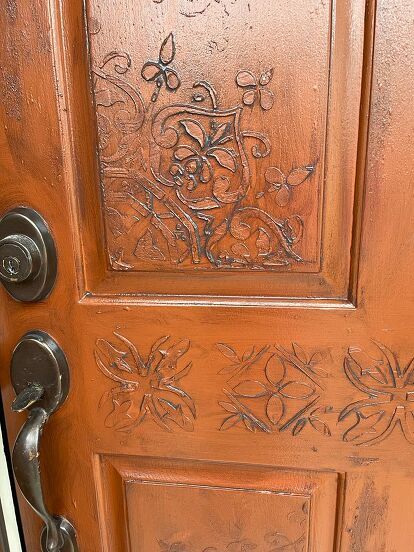 I have been wanting to do something with my front door for a while. So, I finally had the time and good weather to be able to leave the door open for a few hours. I had bought some stencils I wanted to use to create a "raised" design since I couldn't have a "carved" one. This is the before. I had painted my door a long time ago with an exterior reddish brown color which I still loved as my background. This is the after. If you like this, follow along so that you can see how I did… Front Door Stencil Ideas, Stenciled Doors, Leave The Door Open, Orange Front Doors, Indoor Ideas, Garage Entry, Wood Putty, Mandala Stencils, Good Weather