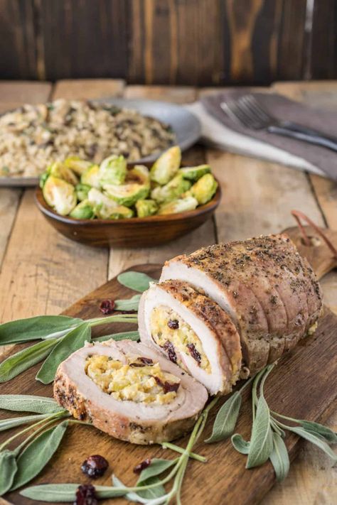 Pork loin is sliced and opened flat, then stuffed with apple, dried cranberries, cornbread and sage, then rolled and roasted. #porkloin #stuffedporkloin #porkandsage