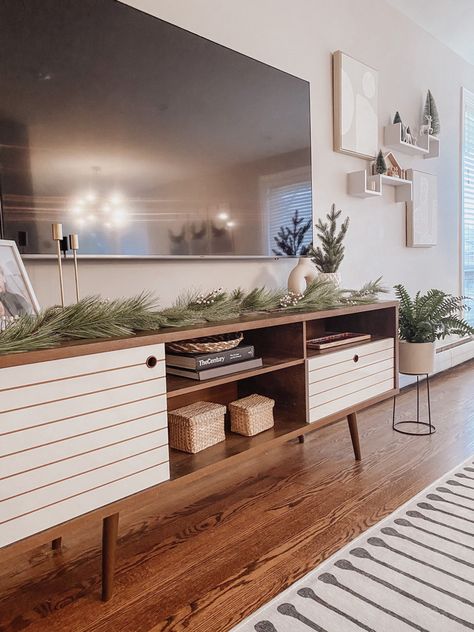 Greenery On Tv Stand, Living Room Designs With Tv Stand, Picture Frames On Tv Stand, Styling A Tv Stand Living Rooms, Styling Tv Stand Living Rooms, Long Tv Stand Decor, Winter Tv Stand Decor, Holiday Tv Stand Decor, Tv Stand Holiday Decor