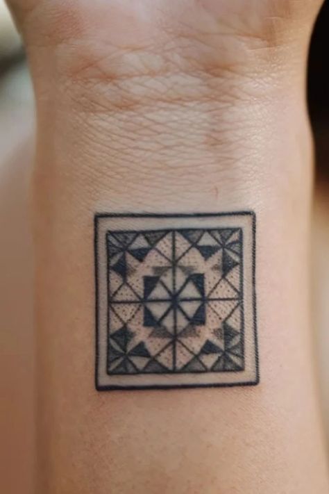 Geometric tattoo with a symmetrical pattern of triangles and squares inside a square frame on skin. Quilt Pattern Tattoo, Granny Square Tattoo, Quilt Square Tattoo, Quilt Tattoos, Square Tattoo Ideas, Tattoo Ideas For Females, Female Tattoo Ideas, Square Tattoo, Tattoo Ideas Inspiration