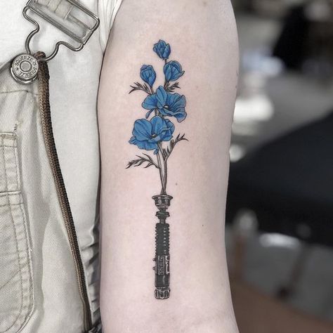 Anakin Obi Wan Tattoo, Starwars Lightsaber Tattoos, Flower Lightsaber Tattoo, Lightsaber With Flowers Tattoo, Star Wars Tiny Tattoo, Obi Wan Tattoo Ideas, Obi Wan Kenobi Lightsaber Tattoo, Star Wars Memorial Tattoo, Lightsaber Flower Tattoo