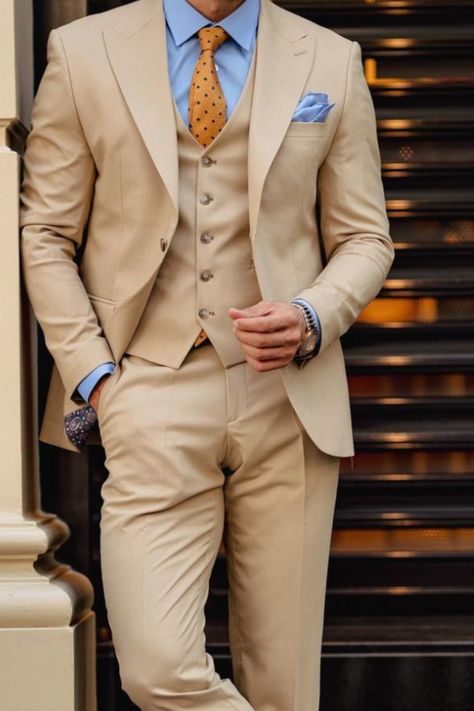 This is a tan three piece suit paired with a an orange patterned tie and baby blue shirt to make for an incredibly simply yet chic outfit. Beige Suit Blue Shirt, Tan Suit Blue Shirt, Beige Three Piece Suit Men, Tan And Blue Suit, Tan Suits For Men, Three Piece Suit Mens Wedding, Tan Suit Men, Mens Three Piece Suit, Beige Suits For Men