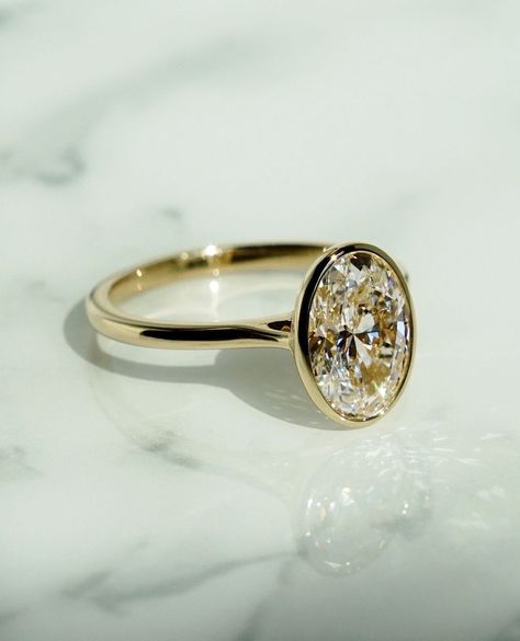 Swipe for the side profile 👀⁠ ⁠ Understated and elegant, this bezel setting is as low maintenance as it gets. Featuring an airy basket… | Instagram Champagne Ring, Engagement Ring Bezel, Anniversary Rings For Her, Oval Cut Moissanite Engagement Ring, Moissanite Solitaire Ring, Oval Cut Ring, Engagement Ring Oval, Oval Diamond Ring, Gold Promise Rings