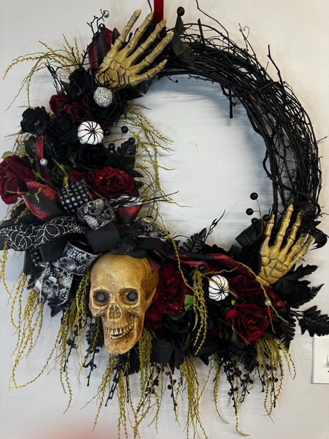 This beautiful Halloween wreath will take your decor to the next level.  A 24 inch grapevine is adorned with skeleton along with black and red florals.  Display on Your front door, over your fireplace or Interior walls will complement your Halloween Decor.  This wreath has a lot of black and red florals, sprays and greenery picks.  A large wired bow with skull and hands poking through and a rhinestone spider to add a touch of bling.  This has a over measurements of 36in x 30in x 9in. To ensure the longevity and quality of this wreath, display indoors or under a sheltered porch to protect from harsh weather conditions. This is not intended for extreme elements.  When not in use store in a cool dry place to maintain its condition.  Bows will need to be fluffed. Grapevine Halloween Wreath, Skull Wreath Diy, Boho Wreaths, Halloween Grapevine Wreath, Halloween Skull Wreath, Wreath Display, Rhinestone Spider, Halloween Door Decor, Skeleton Decor