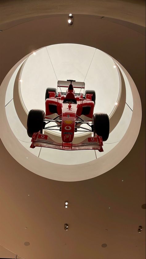 A Ferrari F1 car hanging from the ceiling at the flagship Ferrari store in Milan. F1 Car On Ceiling, F1 Car In House, F1 House Decor, F1 Room Decor Aesthetic, Obsessed Garage, Ferrari F1 Car, Car Lounge, F1 Aesthetic, Nyc Penthouse