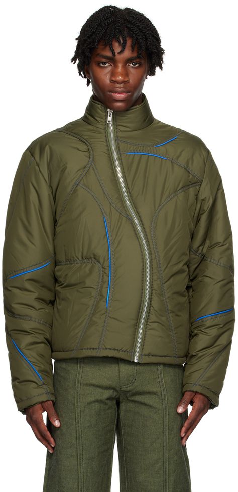 Insulated quilted polyester taffeta jacket. Piping in blue throughout. · Paneled and layered construction · Stand collar · Asymmetric zip closure · Zip pockets · Bungee-style drawstrings at hem · Fully lined · Contrast stitching in blue Supplier color: Green Climbing Fashion, Sports Day Outfit, Mens Jacket Pattern, 90s Activewear, Taffeta Jacket, Quilting Fashion, Unisex Streetwear, Zipper Fashion, Drawstring Jacket