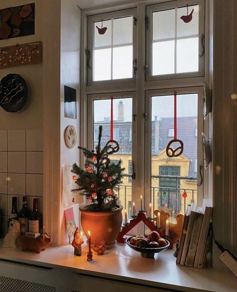 A beautiful window corner decorated with small trees, books, and holiday candles, exuding a cozy, warm holiday vibe where every corner tells a story. Copenhagen Apartment, Window Corner, Coffee Interior, Copenhagen Christmas, Christmas Apartment, Cosy Christmas, Christmas Interiors, Christmas Feeling, Cozy Holiday