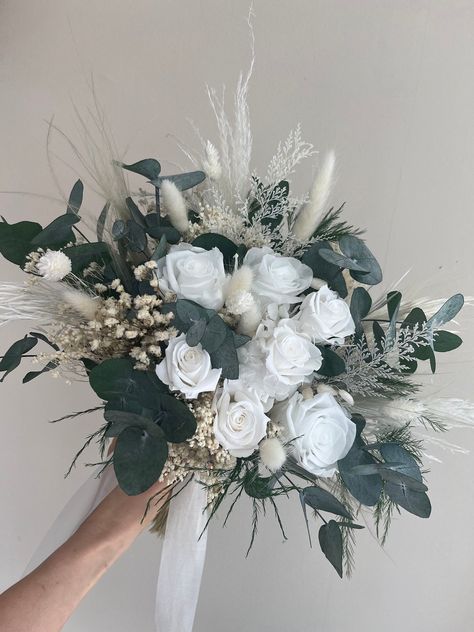 White Preserved Roses Eucalyptus Wedding Bouquet. 🌿 FEATURES The whole thing comprises preserved roses, dried flowers, and unfading eucalyptus (preserved). All material is natural and sustainable. 🌿ADVANTAGES 🧡The flowers will look great for the years to come. 🧡You’ll be able to see it before the big day, enjoy it through the wedding, and keep it as a remembrance of that beautiful day. 🧡The bouquet can travel with you to the venue wherever it is. 🧡Will look amazing in your photos! 🧡A beau Flower Bouquet For Bridesmaids, White Dried Flower Bouquet, Bouquet For Bridesmaids, Bouquet White Roses, Wedding Bouquet White, Eucalyptus Wedding Bouquet, Cascading Bridal Bouquets, Cascading Wedding Bouquets, Round Bouquet