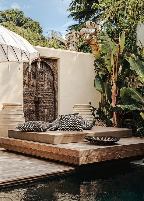 The courtyard is surrounded by a high wall for privacy. The decorative vintage door and oversized pots were sourced in Marrakech. Bohu created a sunbathing platform that can also be used as an informal bench and dining table Bali Bar, Villa Marrakech, French City, Outdoor Dining Tables, Resort Design, Urban Oasis, High Walls, Vintage Door, The South Of France