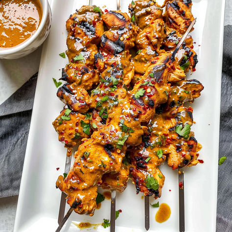 Fire up the grill with these Thai Curry Chicken Skewers! Juicy, flavorful chicken paired with a creamy coconut peanut sauce makes the perfect dish for any BBQ or dinner. Ready in no time and packed with exotic Thai flavors! Chicken Skewers Dinner, Thai Curry Chicken Skewers, Thai Chicken Skewers Grilled, Grilled Thai Coconut Chicken Skewers, Thai Coconut Chicken Skewers, Thai Appetizers For Party, Thai Chicken Tenders, Thai Food Appetizers, Thai Appetizer Recipes