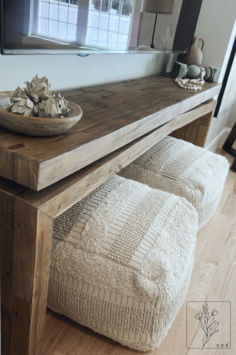 Poufs are a great way to add extra seating to your space. We love how these can easily slip under this console table! Table With Poufs Under, Console Table With Poufs, Console Table With Ottomans Under Tv, Under Tv Seating, Ottoman Under Tv, Ottoman Under Console Table, Under Tv Table, Console Table With Ottomans, Black Leather Living Room Furniture